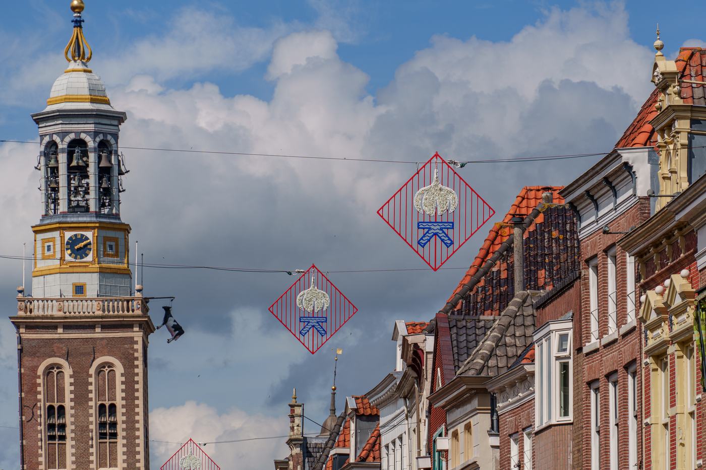 A decorated shopping street below an old clock tower