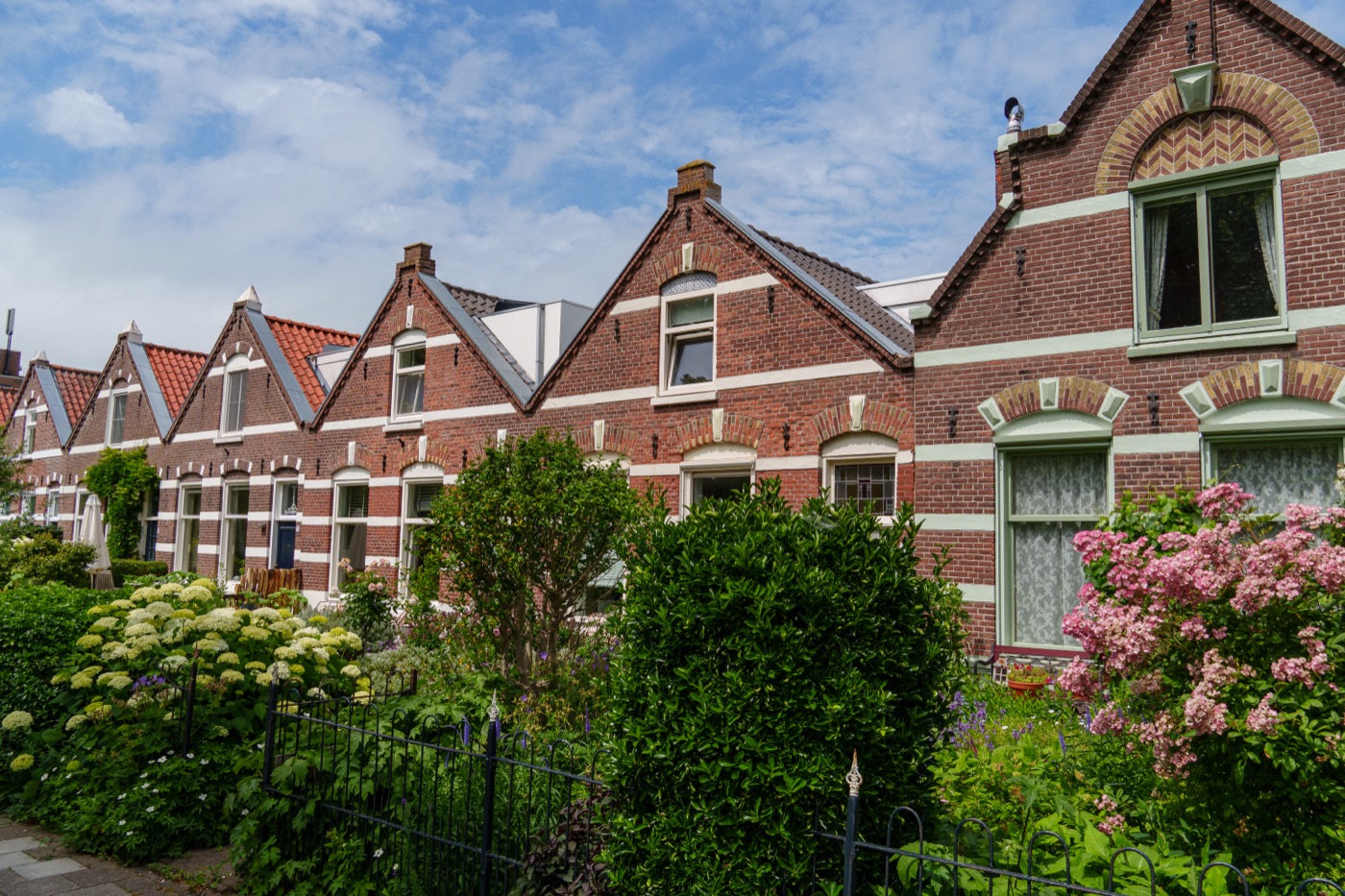 Row of traditional brick houses with front gardens