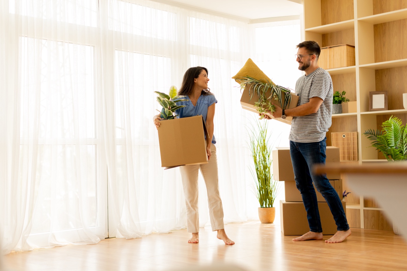 Couple carrying boxes into a new apartment